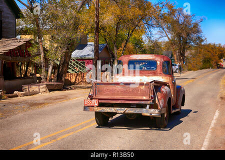 Old 1960s Chevy pickup truck driving down highway NM-14 in Madrid, New Mexico Stock Photo