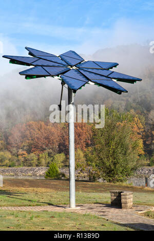 Solar array identified as  'Solar Photovoltaic Flair',  facilitates electric vehicle charging station, dissipating morning fog. Stock Photo