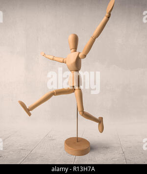 Wooden mannequin posed in front of a greyish background Stock Photo