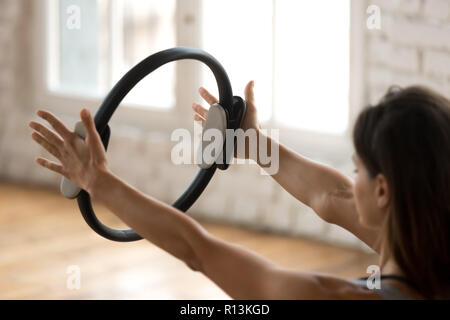 Young sporty woman practicing fitness exercise with a pilates ri Stock Photo