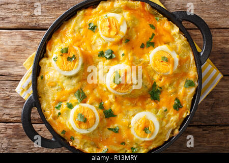 Authentic British food. Anglesey eggs baked with mashed potatoes, leek cheese sauce close-up on the table. horizontal top view from above Stock Photo