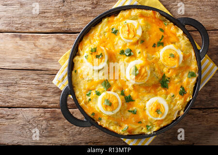 The traditional Welsh dish of Anglesey Eggs cooked from boiled potatoes, leek cheese sauce, and eggs close-up on the table. horizontal top view from a Stock Photo