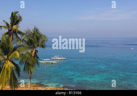 Traditional banka boats on peaceful turquoise water in Apo Island, Philippines. Paradise travel destination, summer vacation, relax concepts Stock Photo