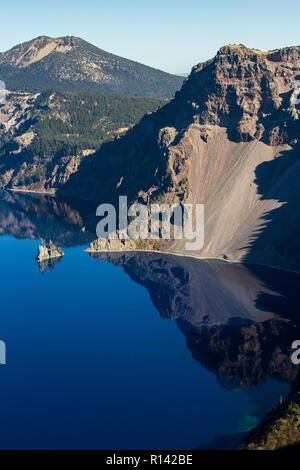 Phantom ship feature in Crater Lake national park, with beautiful reflection on the deep blue water Stock Photo