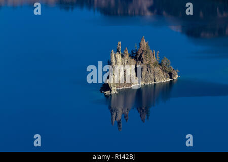 Phantom ship feature in Crater Lake national park, with beautiful reflection on the deep blue water Stock Photo