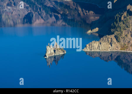 Phantom ship feature in Crater Lake national park, with beautiful reflection on the deep blue water Stock Photo