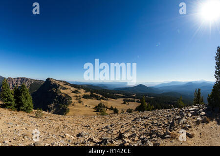 View from the top of Garfields Peak in Crater Lake NP, with a section of pumice dessert fading into the dense forest of the Cascades Stock Photo