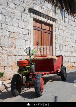 Vintage old tractor in front of stone house on island Vis in Croatia Stock Photo
