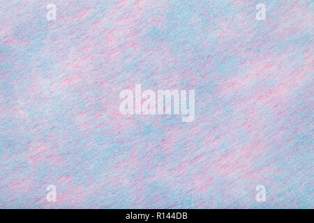 Construction of a light blue background with pink spots of felt fabric, closeup. Texture of woolen matt textile. Cloth backdrop. Stock Photo