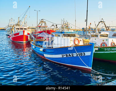 Typical Mediterranean boats moored in the fishing harbor of Palamos at sunset. Baix Emporda, Girona, Catalonia, Spain. Stock Photo