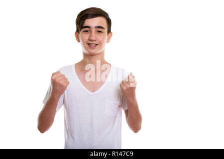 Studio shot of young happy Persian teenage boy smiling while loo Stock Photo