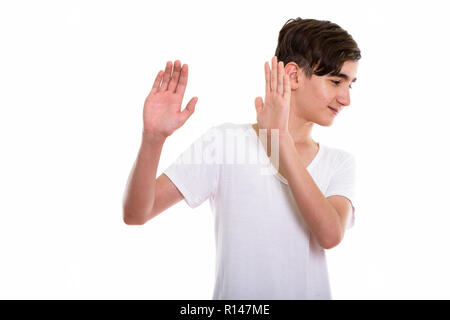 Studio shot of young handsome Persian teenage boy looking away w Stock Photo