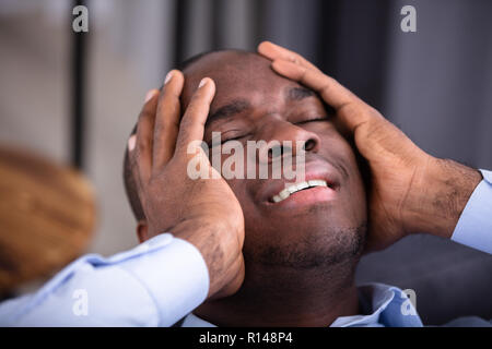 Close-up Of A Young African Man In Pain Holding His Stomach Stock Photo