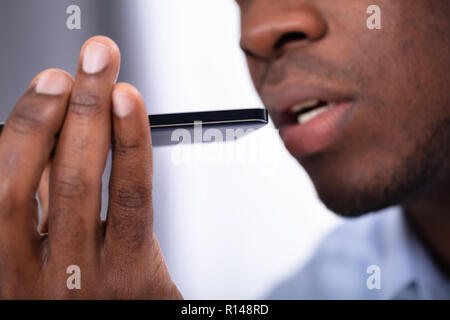 Close-up Of An African Man Using Voice Assistant On Cellphone Stock Photo