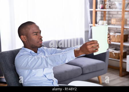 Side View Of A Young African Man Holding Book Stock Photo
