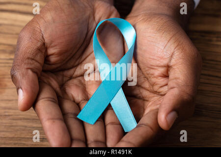 Close-up Of A Person's Hand Showing Ribbon To Support Cervical Awareness Stock Photo