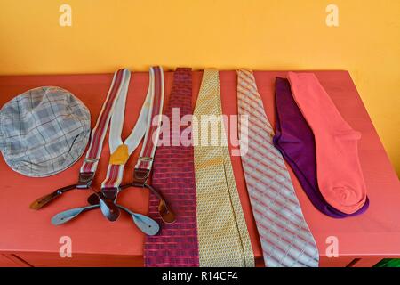 Man garments. Clothing concept for men. Colorful socks, ties, braces and checked flat cap on claret background. Classical concept of men garments Stock Photo