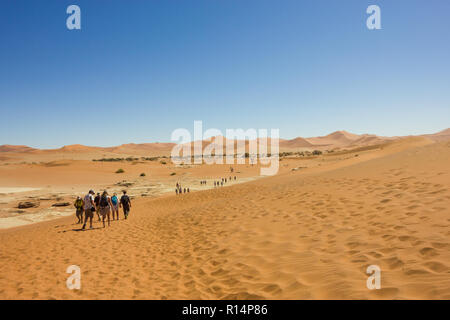 people walking on the sand dunes at Sossusvlei in the Namib Naukluft National park in Namibia on a Winters day Stock Photo