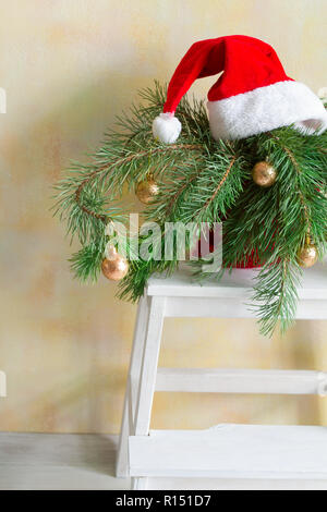 Christmas tree branches in a pot on a chair, home holidays decor Stock Photo