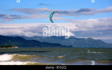 Kite surf rider on a sea waves in summer day. Perfect wind and weather Stock Photo