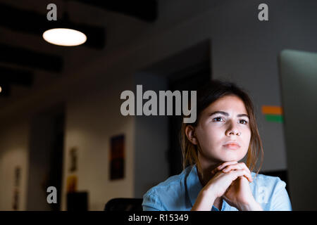 Photo of concentrated young woman graphic designer using pc computer working at night in office. Stock Photo