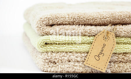 Pile of organic cotton bath towels on white background. Eco textile tag. Stock Photo