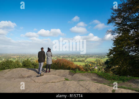 Young couple stood looking at the Cheshire countryside from Alderley Edge, Cheshire, England. Stock Photo