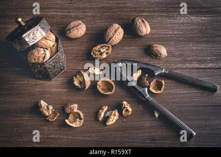 Walnuts lying on a brown tray with a nutcracker Stock Photo