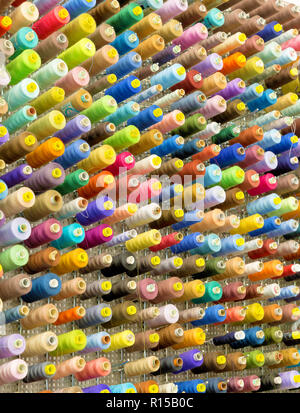 Organized wall of spools with sewing threads in many color variations Stock Photo