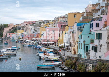 Panoramic photo of Marina Corricella, unspoilt fishing village on the island of Procida Italy, with pastel coloured houses overlooking the harbour. Stock Photo