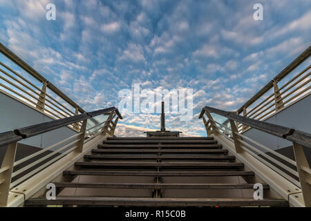 Abstract picture of a wooden staircase going up to the regular blue clouds shape sky Stock Photo