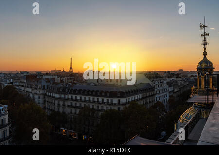 Yellow vivid sunset on Paris roof of ancient stone Victorian buildings with the Eiffel Tower not lit yet, France