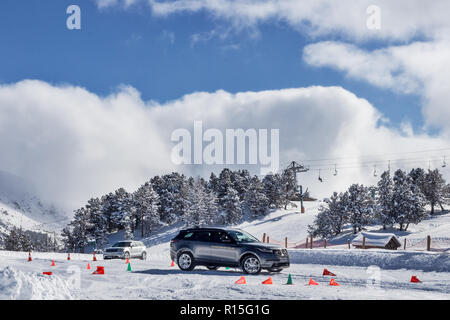 PYRENEES, ANDORRA - FEBRUARY 7, 2018: Test drive the Land Rover on a snow-covered road. Winter trail in the mountains, sunny winter day Stock Photo