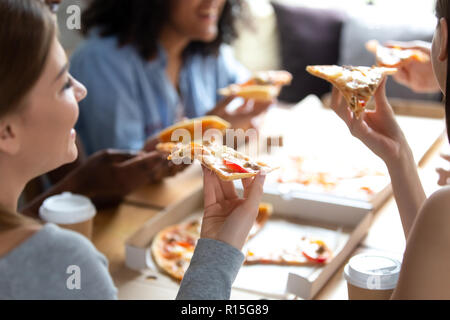 Diverse multiracial best friends students spending free time together take break have lunch sitting around table eating enjoying conversation with eac Stock Photo