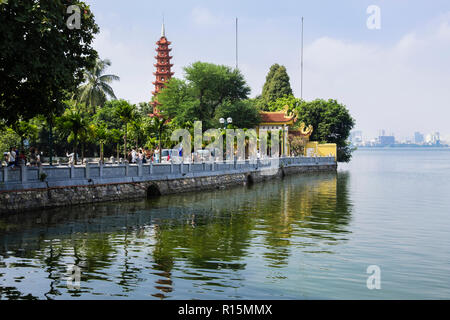 Tourists on causeway leading to Tran Quoc Pagoda and temple on West Lake. Hanoi, Vietnam, Asia Stock Photo