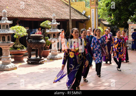 Asian women in tradional dress visiting Tran Quoc temple. Hanoi, Vietnam, Asia Stock Photo