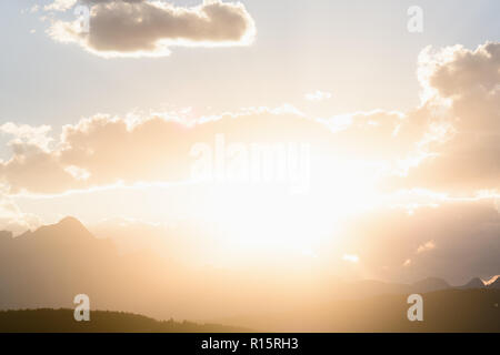 Sun peaks out from behind the clouds over Crowsnest Mountain and Seven Sisters Mountain Stock Photo