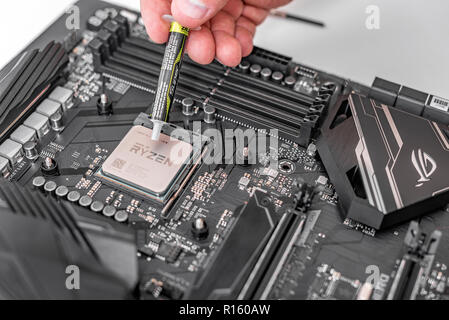 Engineer applying thermal paste on the computer board chip cpu. Stock Photo