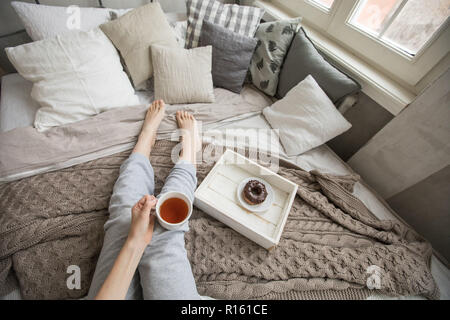 Crop woman having breakfast on bed Stock Photo
