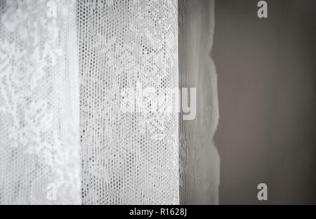 White curtain decorated with sewed floral pattern in lace. Interior shot with natural soft light Stock Photo