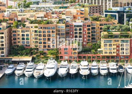 3 November 2018 - Monaco,  Principality of Monaco. Modern boats neatly parked in the harbor near luxury apartments in Monaco. Stock Photo