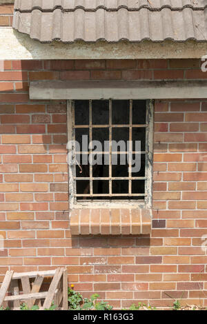 A close up view of the side window meatal frame of an abandeded building Stock Photo