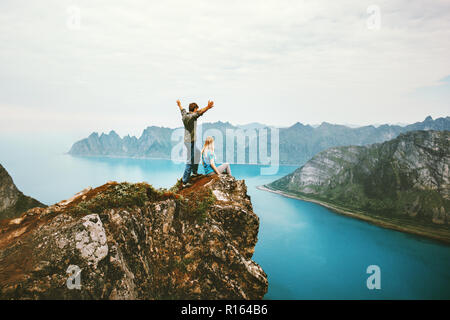 Travel couple enjoying view together on cliff edge in Norway man and woman family healthy traveling lifestyle summer vacations outdoor success friends Stock Photo