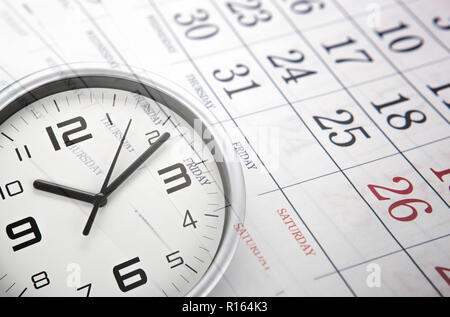 wall calendar with the number of days and white clock face closeup Stock Photo