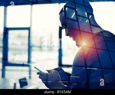 Businessman works with his smartphone in office. double exposure Stock Photo