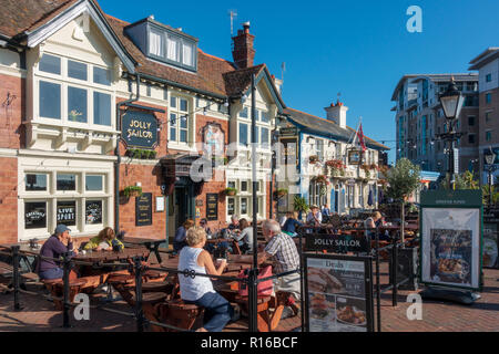 People sitting outside seafront pubs The Jolly Sailor and The Lord Nelson in Poole, Dorset, England Stock Photo