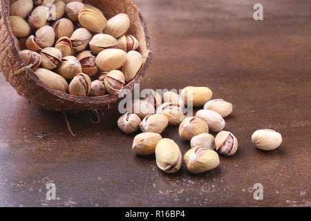 handmade bowl of coconut with pistachios on a stone table. Close-up. Stock Photo