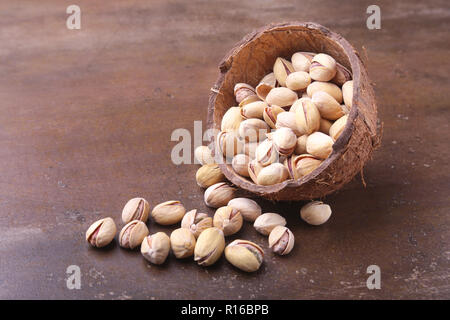 handmade bowl of coconut with pistachios on a stone table. Close-up. Stock Photo
