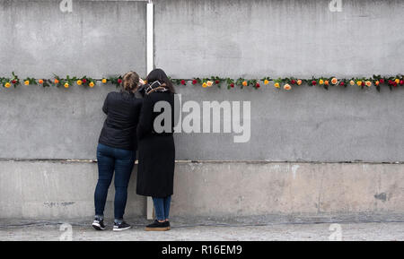 Berlin, Germany. 09th Nov, 2018. Participants of a commemoration ceremony for the 29th anniversary of the fall of the Berlin Wall are stuck at the wall monument Bernauer Straße roses between remains of the former Berlin Wall. Credit: Ralf Hirschberger/dpa/Alamy Live News Stock Photo