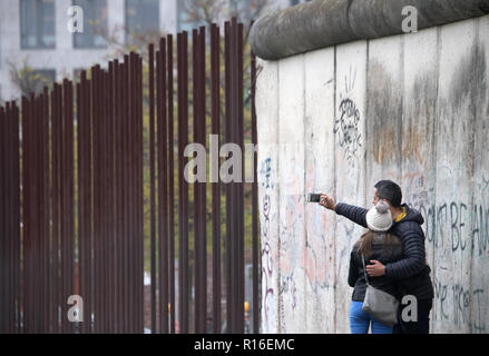 Berlin, Germany. 09th Nov, 2018. Before a commemoration ceremony for the 29th anniversary of the fall of the Berlin Wall at the Bernauer Strasse Wall Memorial, tourists take photographs of the remains of the former Berlin Wall. Credit: Ralf Hirschberger/dpa/Alamy Live News Stock Photo